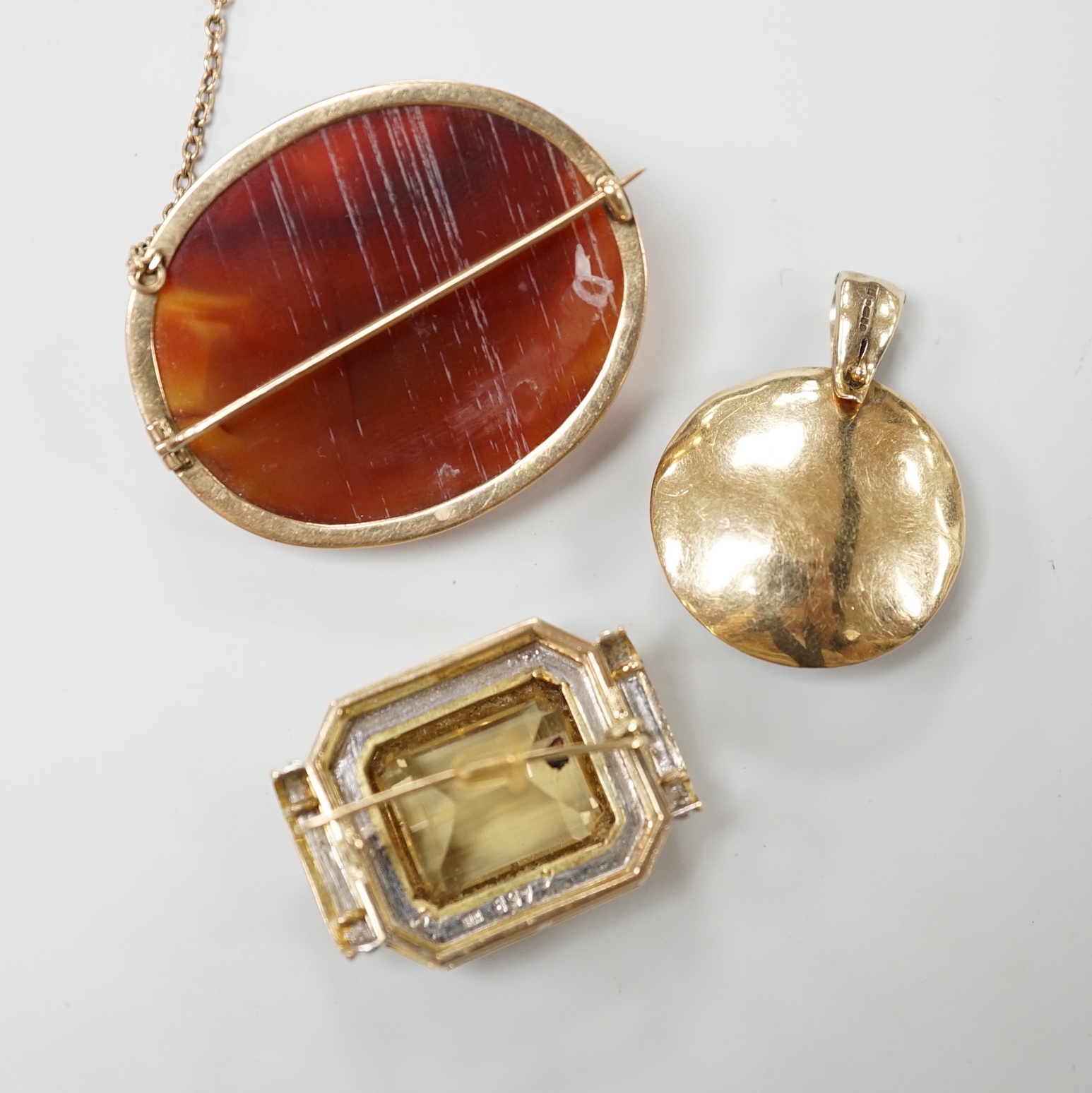 A modern 9ct gold, peridot, amethyst and simulated diamond cluster set circular pendant, diameter 27mm, together with a 9k and citrine set brooch and a yellow metal and facetted agate set brooch.
